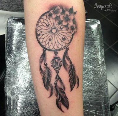  Tatouage attrape rêve avec trois petites fleurs sur l'avant bras